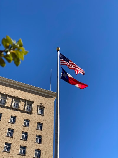 白天，美国国旗挂在大楼附近的杆子上